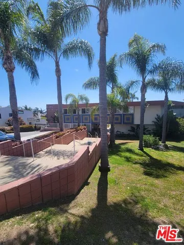a view of a backyard with a patio and palm tree
