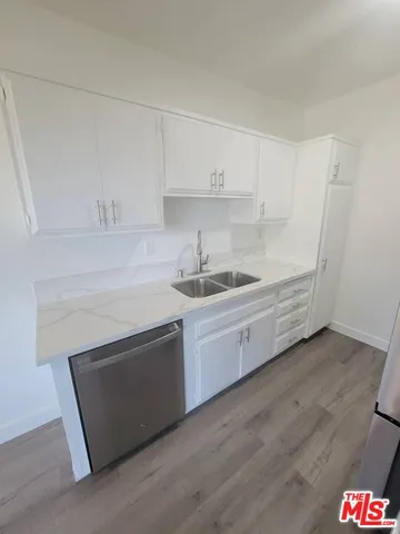 a kitchen with stainless steel appliances white cabinets and a sink