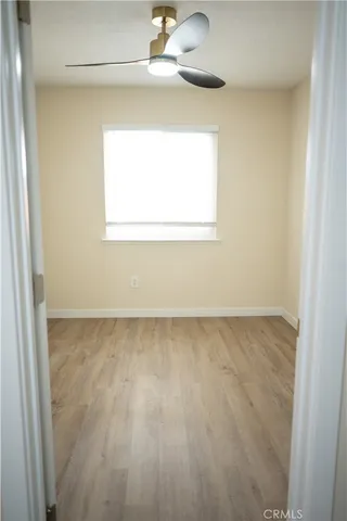 a view of a small space with wooden floor and a window