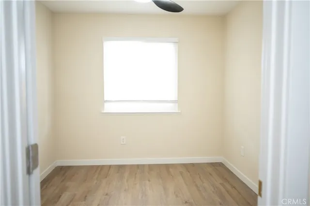 a view of a small space with wooden floor and a window