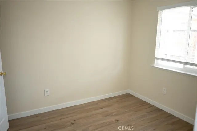 a view of a small space with wooden floor and a window