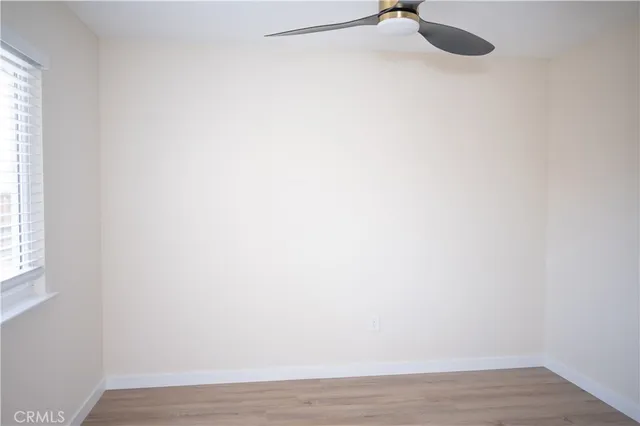 a view of a small space with wooden floor and a window