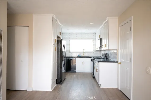 a kitchen with a refrigerator a stove top oven and sink