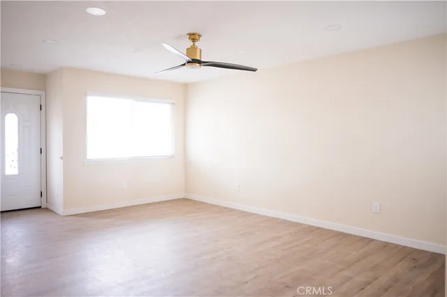 an empty room with a window and a ceiling fan