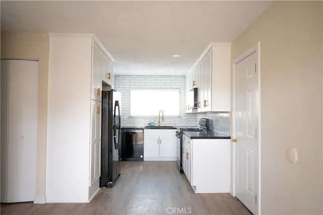 a kitchen with a sink a refrigerator and cabinets