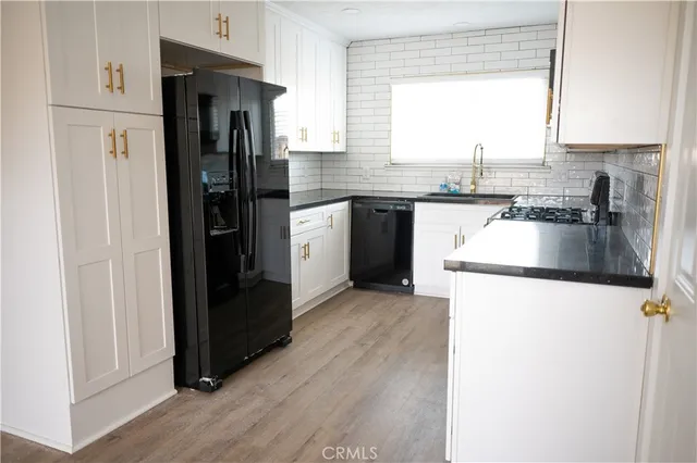 a kitchen with granite countertop a refrigerator and a sink