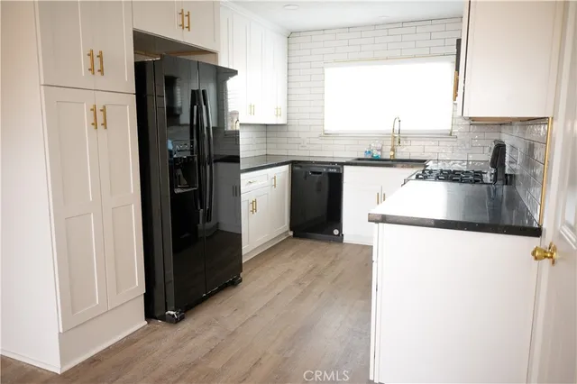 a kitchen with granite countertop a refrigerator and a sink