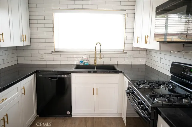 a kitchen with a sink a stove and cabinets