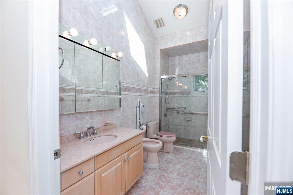 499 Morse Avenue Ridgefield, NJ 07657 - Photo 24 of 45 a bathroom with a granite countertop sink a toilet and shower