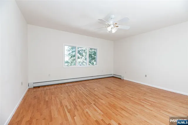 a view of a room with a hallway and wooden floor
