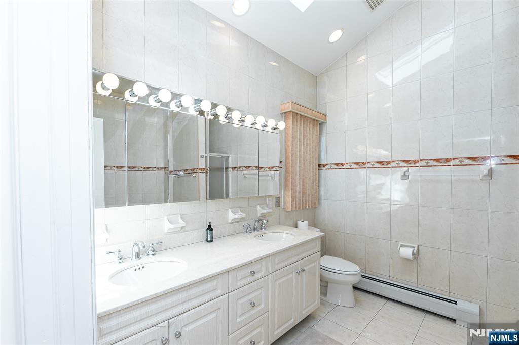 499 Morse Avenue Ridgefield, NJ 07657 - Photo 32 of 45 a bathroom with a double vanity sink mirror double and shower
