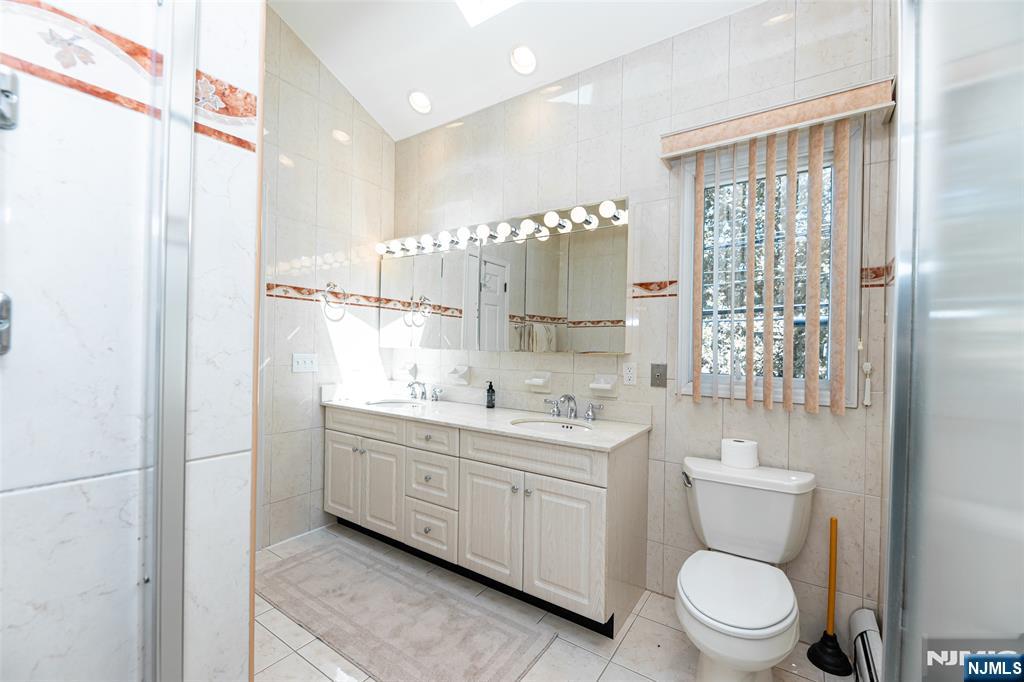 499 Morse Avenue Ridgefield, NJ 07657 - Photo 34 of 45 a bathroom with a toilet a sink and a large mirror