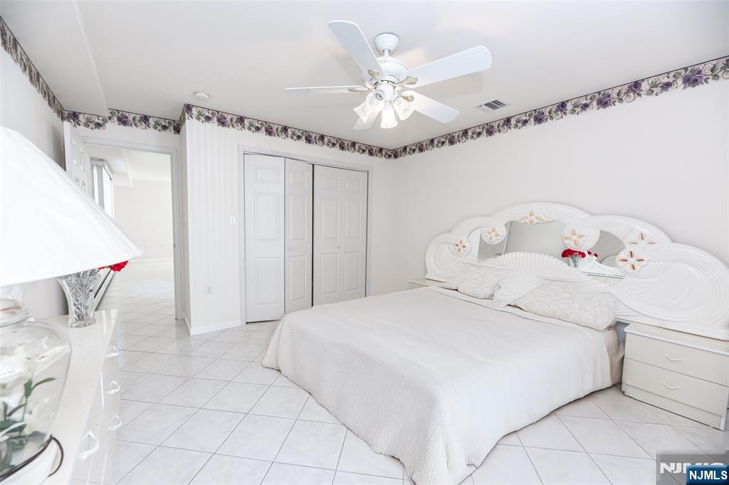 499 Morse Avenue Ridgefield, NJ 07657 - Photo 8 of 45 a bedroom with a large bed and a chandelier
