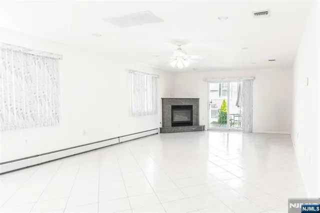 an empty room with windows and fireplace