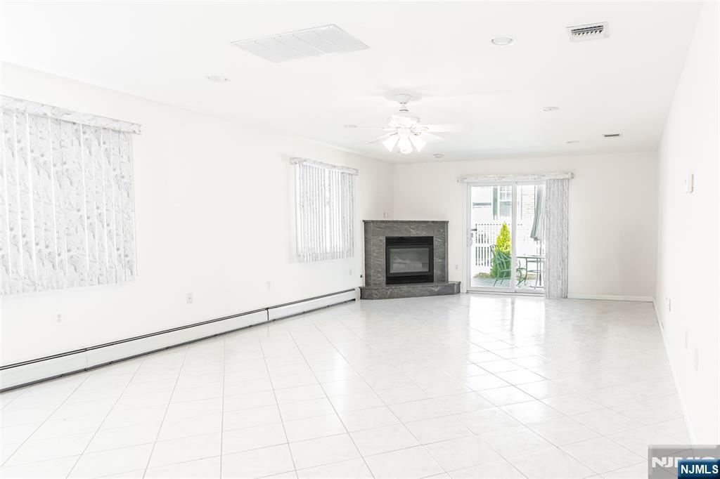 499 Morse Avenue Ridgefield, NJ 07657 - Photo 10 of 45 an empty room with windows and fireplace