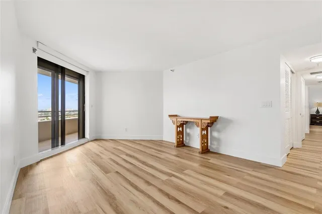 a view of a livingroom with wooden floor and a bathroom