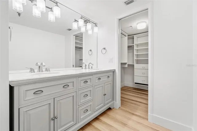a spacious bathroom with a double vanity sink a mirror and a shower