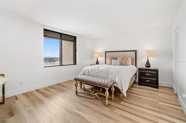 a bedroom with a bed lamp on table and a window