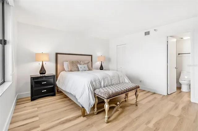 a bedroom with a bed and wooden floor