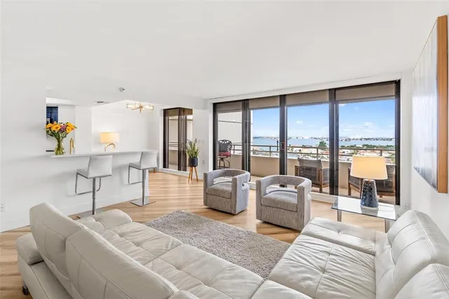 a living room with furniture and floor to ceiling windows