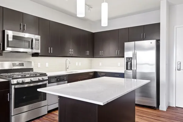 a kitchen with stainless steel appliances a microwave a sink and cabinets