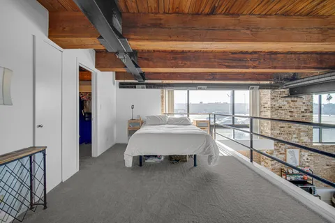 a spacious bedroom with a bed and large window