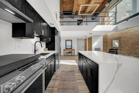 a large kitchen with stainless steel appliances granite countertop a large stove top oven and cabinets