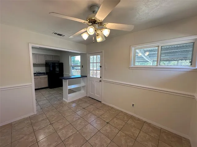 a view of an empty room with a kitchen
