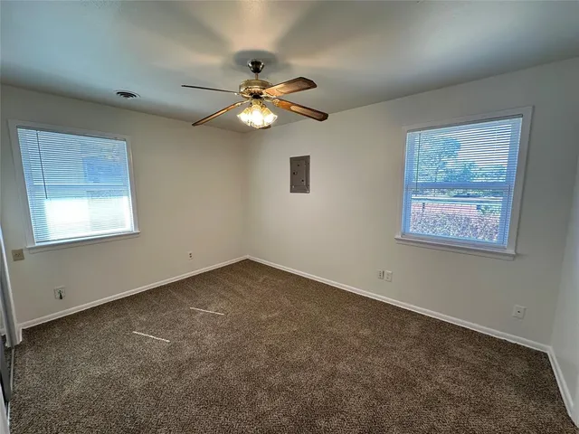 an empty room with a window and a fan