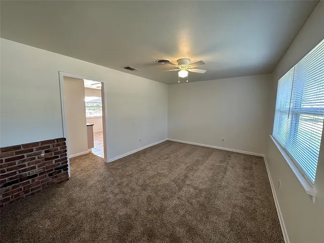 an empty room with windows and fan