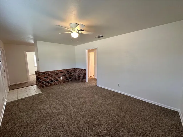 en empty room with windows and ceiling fan