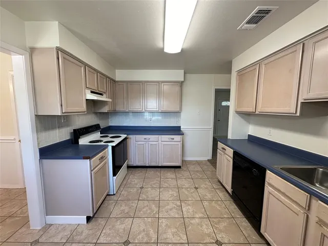 a kitchen with stainless steel appliances granite countertop a stove a sink dishwasher and a refrigerator