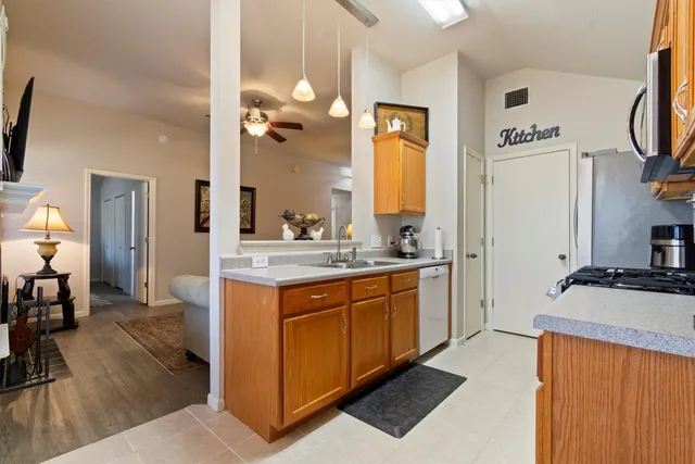 a spacious bathroom with stainless steel appliances granite countertop a sink and a refrigerator