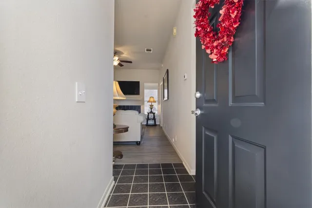 a hallway with a flower pot and a bookshelf
