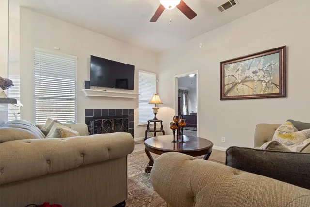 a living room with furniture a flat screen tv and a fireplace