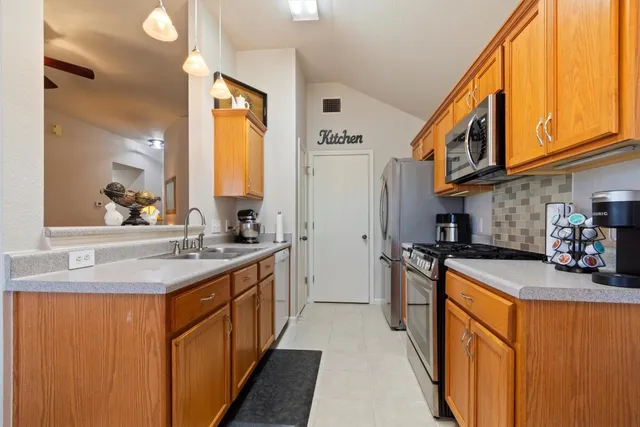 a kitchen with stainless steel appliances granite countertop a sink stove and refrigerator