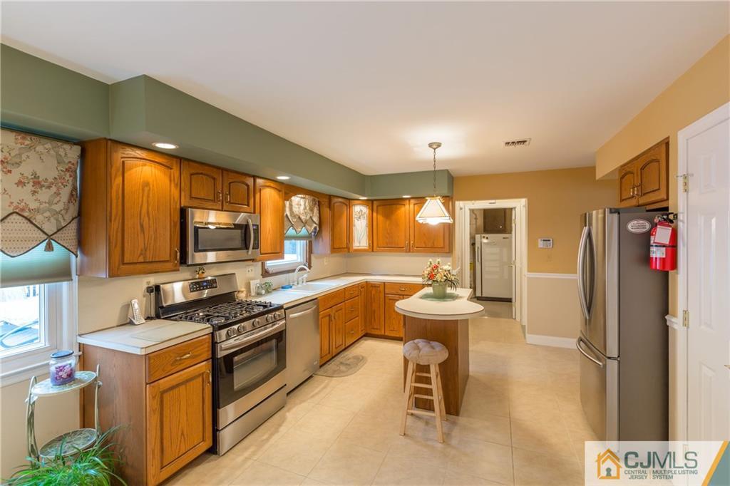 64 Higgins Road Old Bridge, NJ 08857 - Photo 8 of 25 a kitchen with stainless steel appliances granite countertop a sink stove and refrigerator