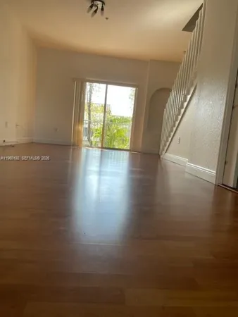 a view of a room with wooden floor and windows