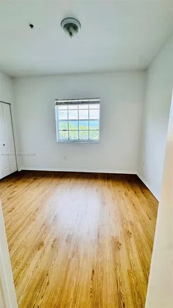 an empty room with wooden floor and a window