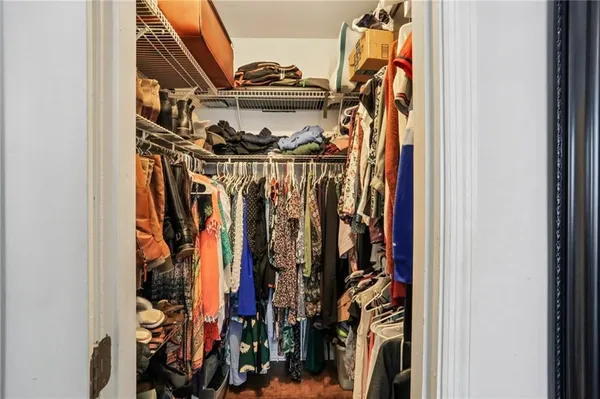 a view of walk in closet with clothes