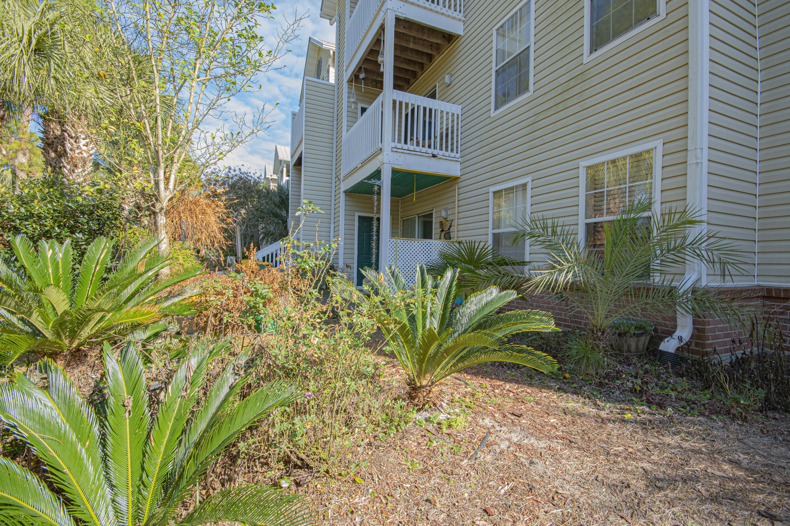 4080 Dancing Cloud Court, Unit 218 Destin, FL 32541 - Photo 26 of 28 a view of a brick house with plants and large trees