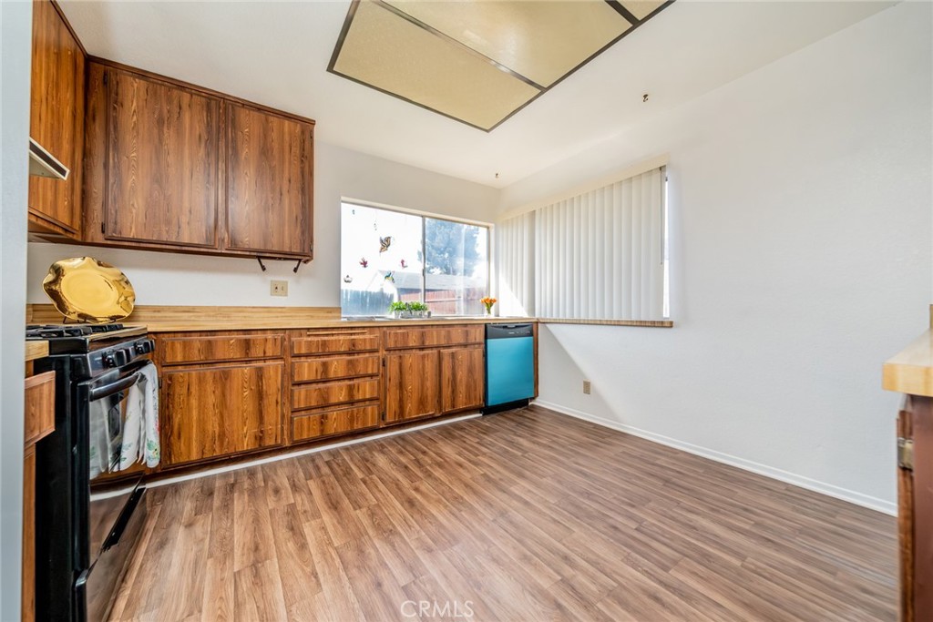 1385 West Wedgewood Street Rialto, CA 92376 - Photo 11 of 27 a kitchen with stainless steel appliances granite countertop a sink stove and wooden cabinets