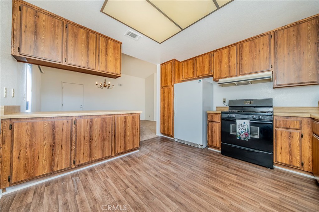 1385 West Wedgewood Street Rialto, CA 92376 - Photo 9 of 27 a kitchen with wooden floors and a kitchen view