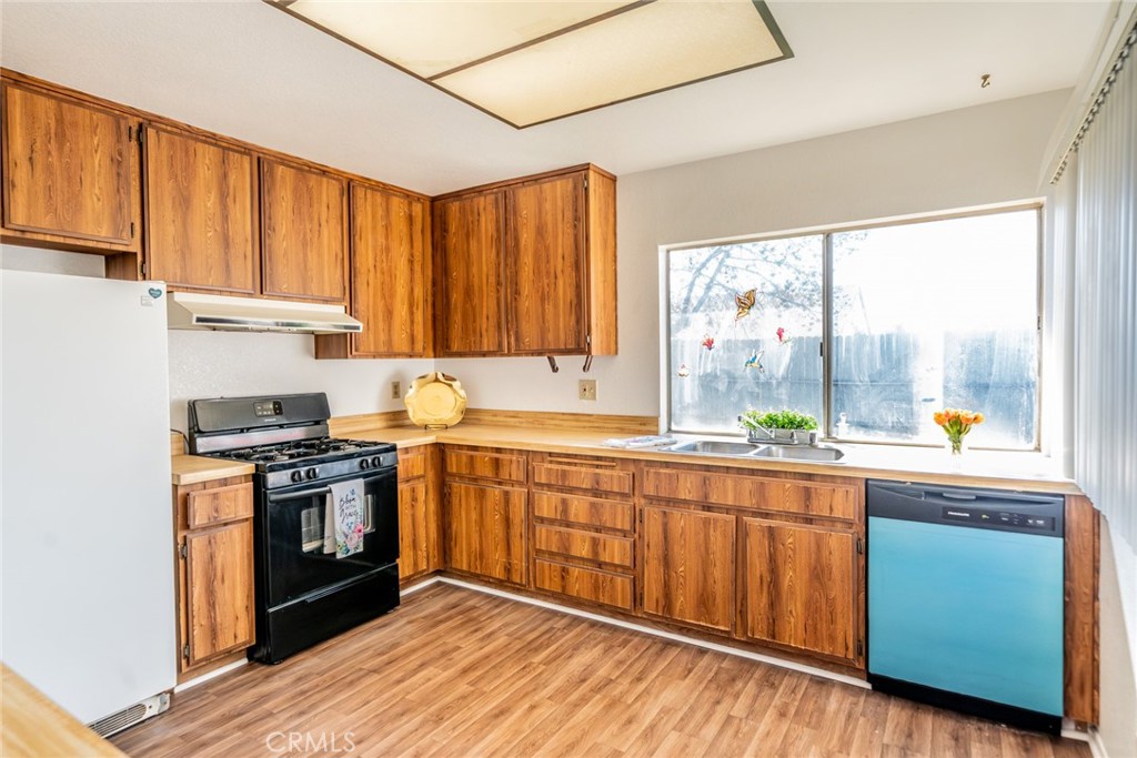 1385 West Wedgewood Street Rialto, CA 92376 - Photo 10 of 27 a kitchen with stainless steel appliances granite countertop wooden cabinets a sink and a stove