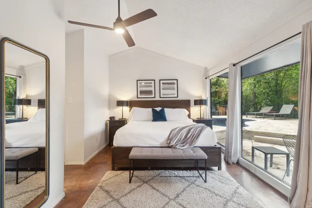 a bedroom with a bed and large windows