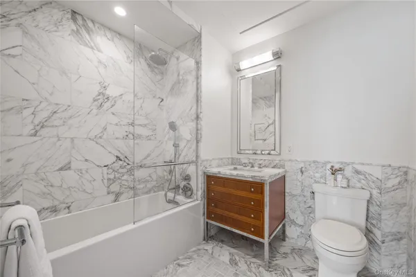 a bathroom with a granite countertop toilet a sink and bathtub