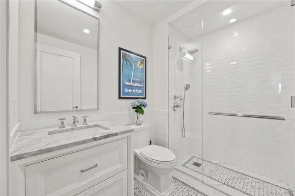 a bathroom with a granite countertop sink toilet a shower and a mirror