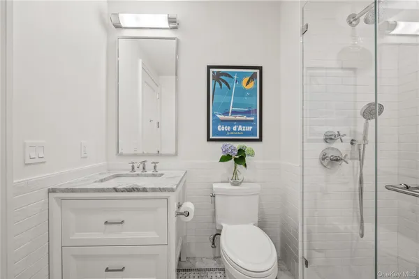 a bathroom with a granite countertop toilet sink and mirror