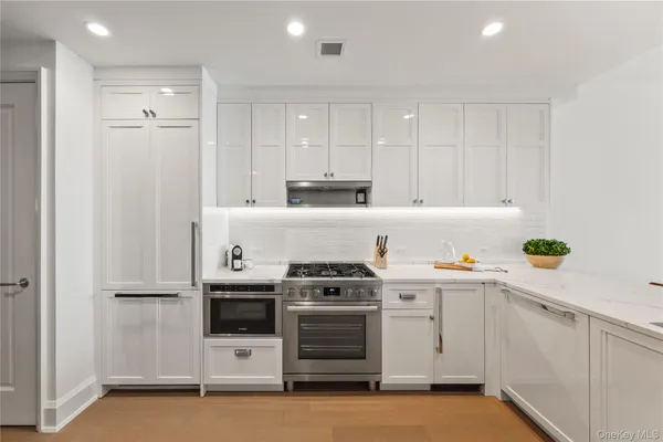 a kitchen with stainless steel appliances a stove a sink and a refrigerator
