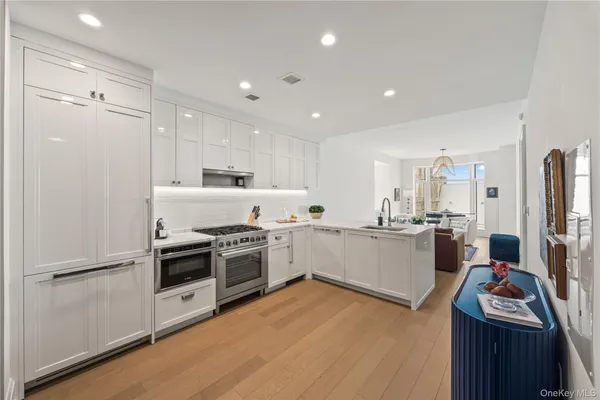 a kitchen with white cabinets and stainless steel appliances